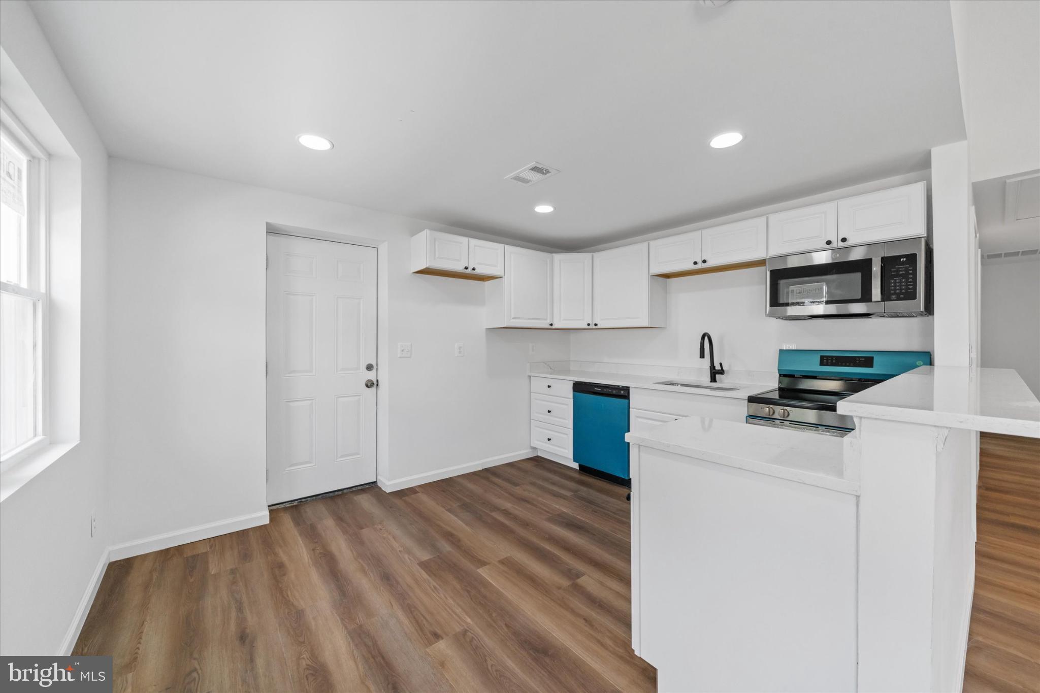 214 Keiser Place New Castle, DE 19720 - Photo 9 of 23 a kitchen with kitchen island a sink dishwasher a stove and a refrigerator with wooden floor