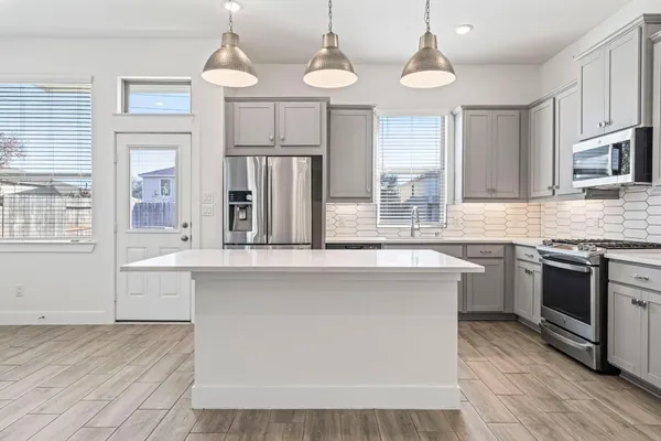 a kitchen with granite countertop a sink stainless steel appliances and cabinets