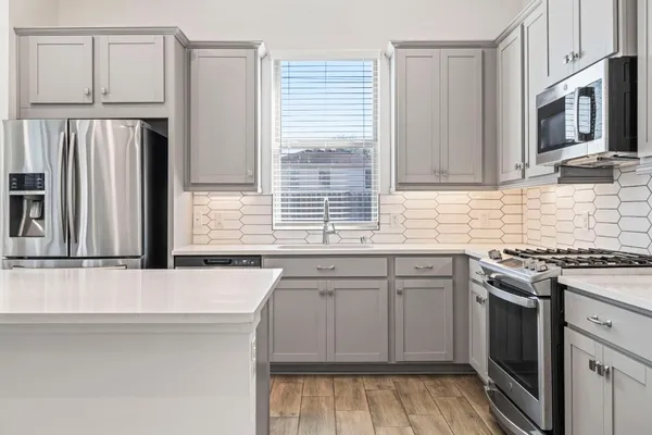 a kitchen with kitchen island granite countertop a stove a sink and a refrigerator