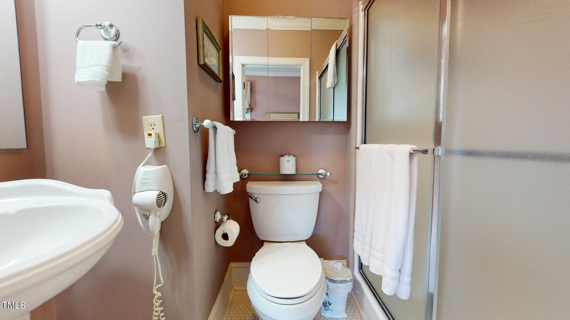 238 North Main Street Wake Forest, NC 27587 - Photo 36 of 100 a white toilet sitting next to a bathroom sink and mirror