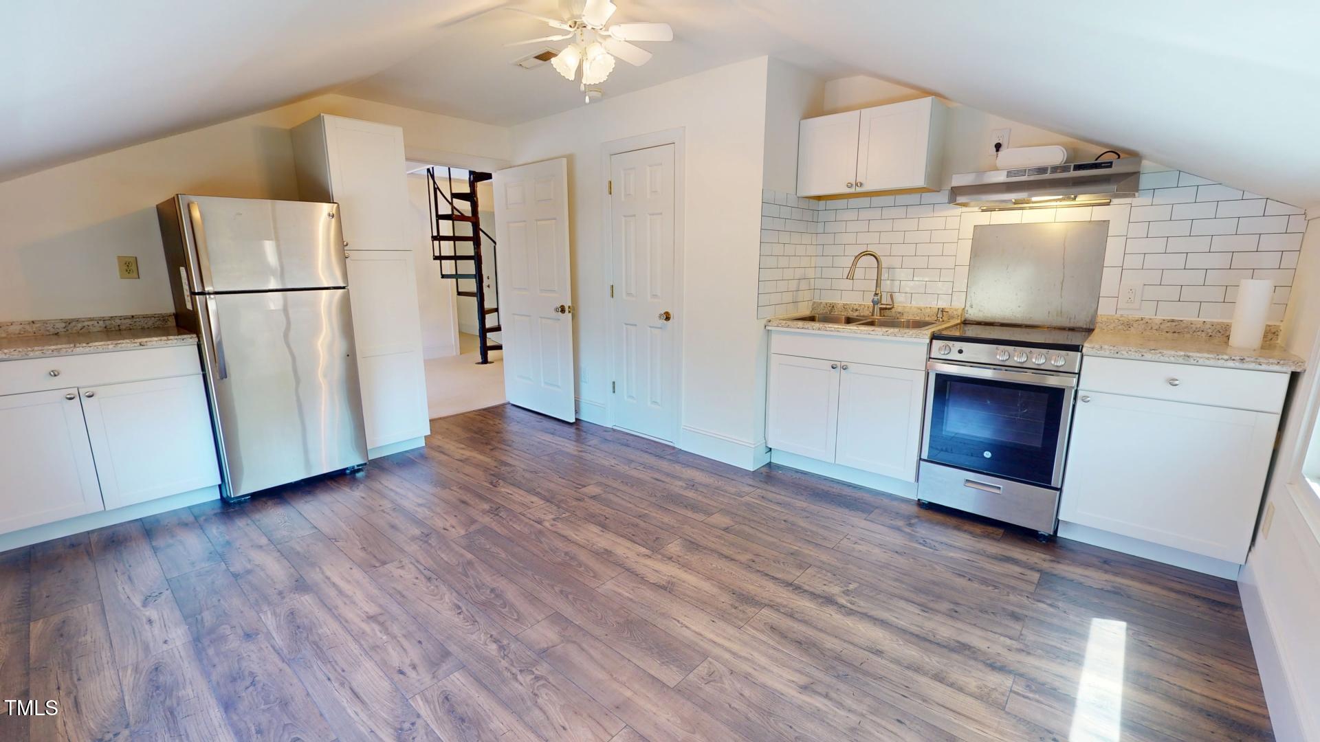 238 North Main Street Wake Forest, NC 27587 - Photo 41 of 100 a kitchen with granite countertop a refrigerator and a stove top oven