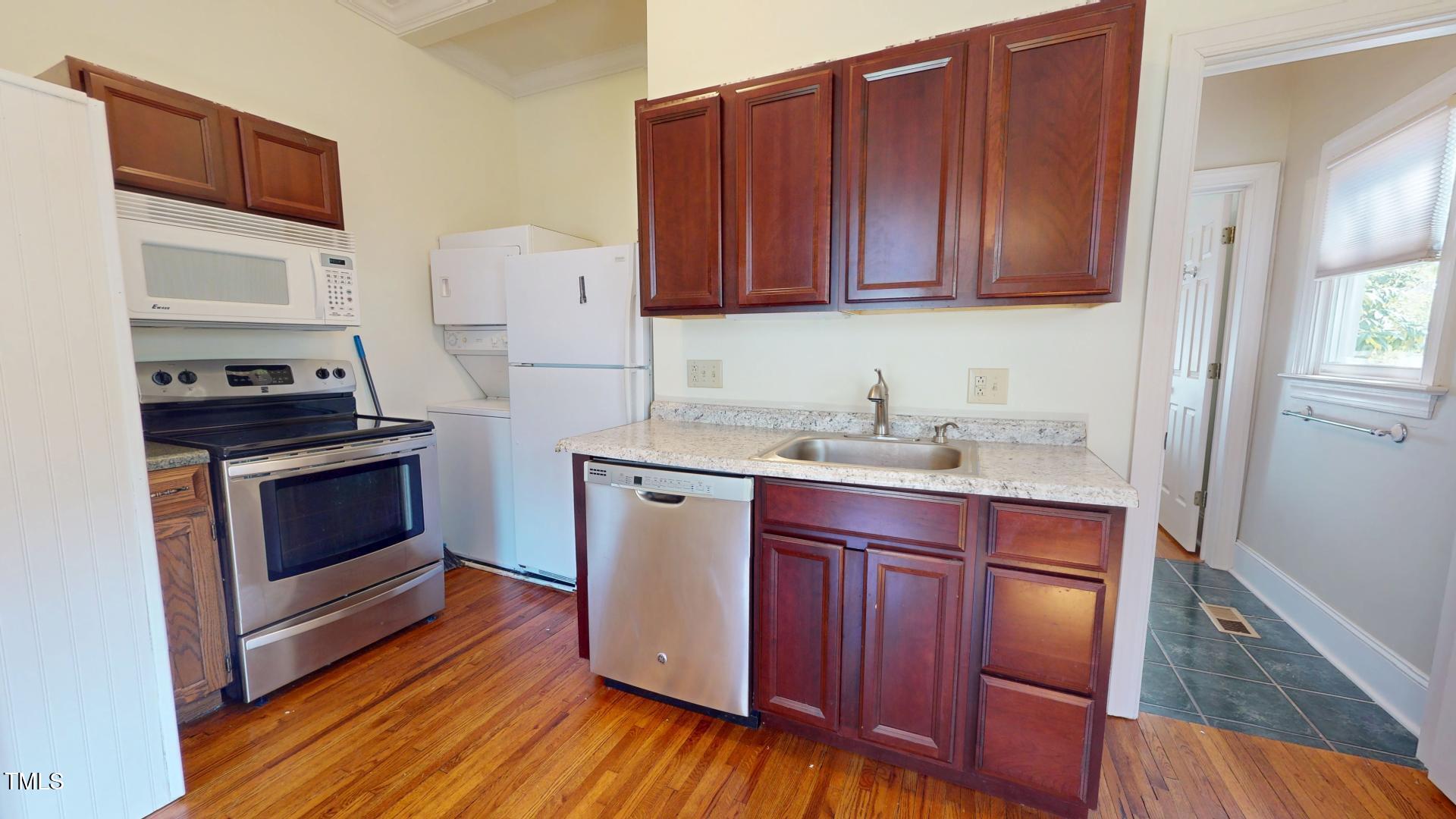 238 North Main Street Wake Forest, NC 27587 - Photo 69 of 100 a kitchen with granite countertop wooden cabinets and white appliances