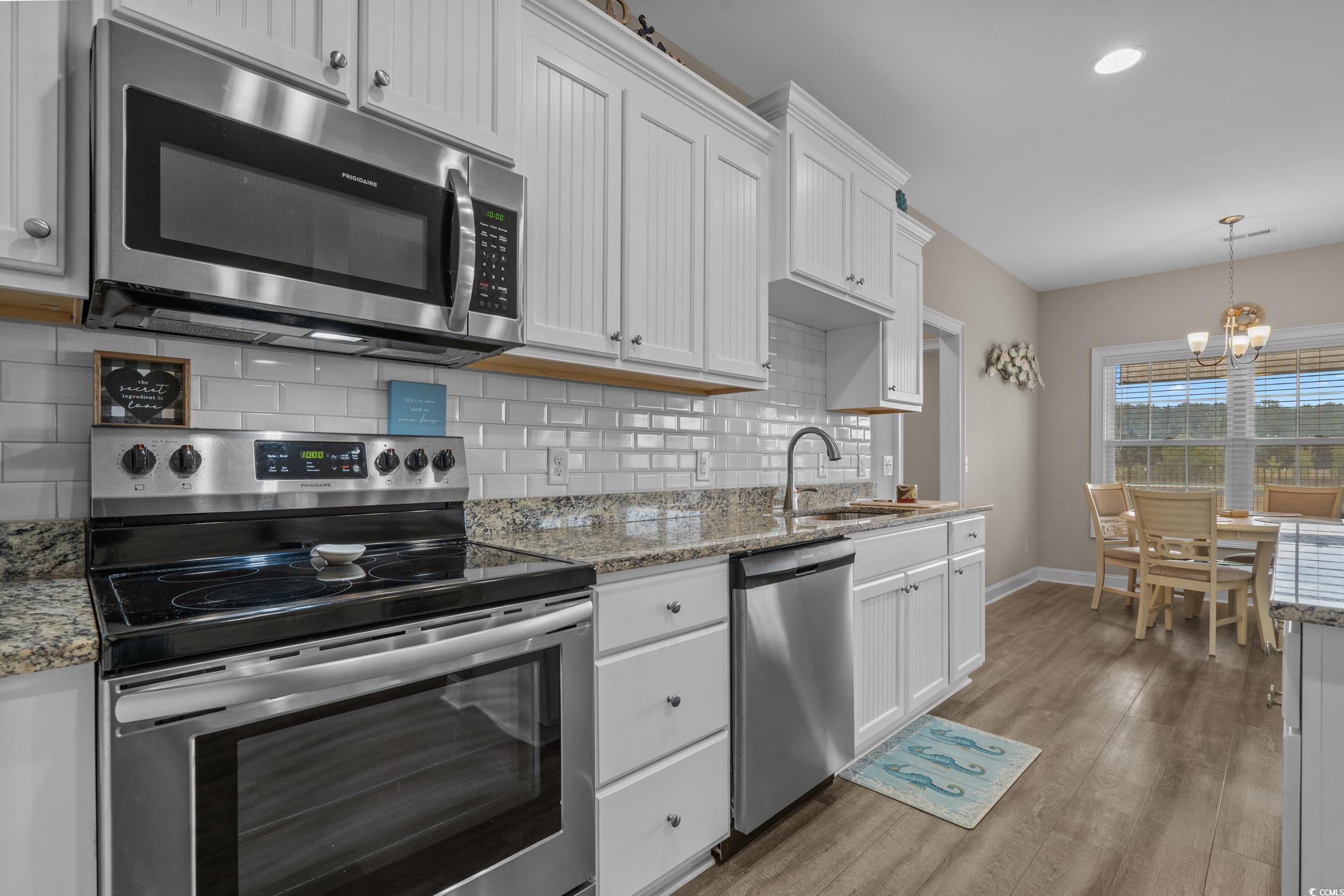 3624 Edwards Road Aynor, SC 29511 - Photo 13 of 40 Kitchen with stainless steel appliances, backsplash, white cabinetry, dark wood-style floors, and a chandelier