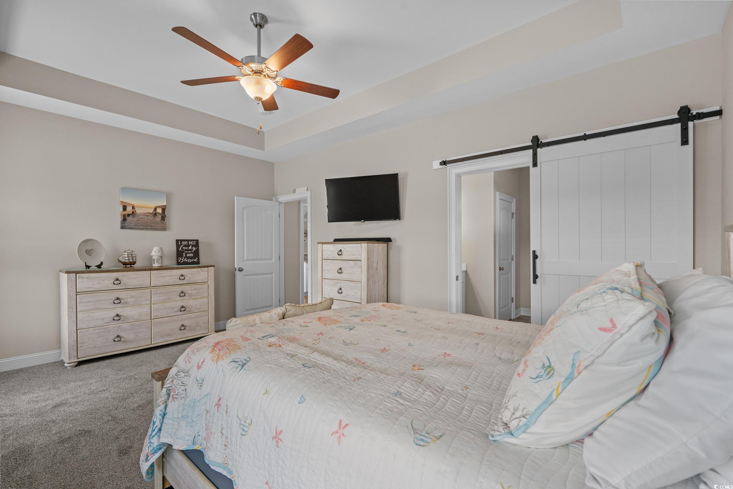 3624 Edwards Road Aynor, SC 29511 - Photo 22 of 40 Carpeted bedroom featuring a raised ceiling, a barn door, a ceiling fan, and ensuite bath