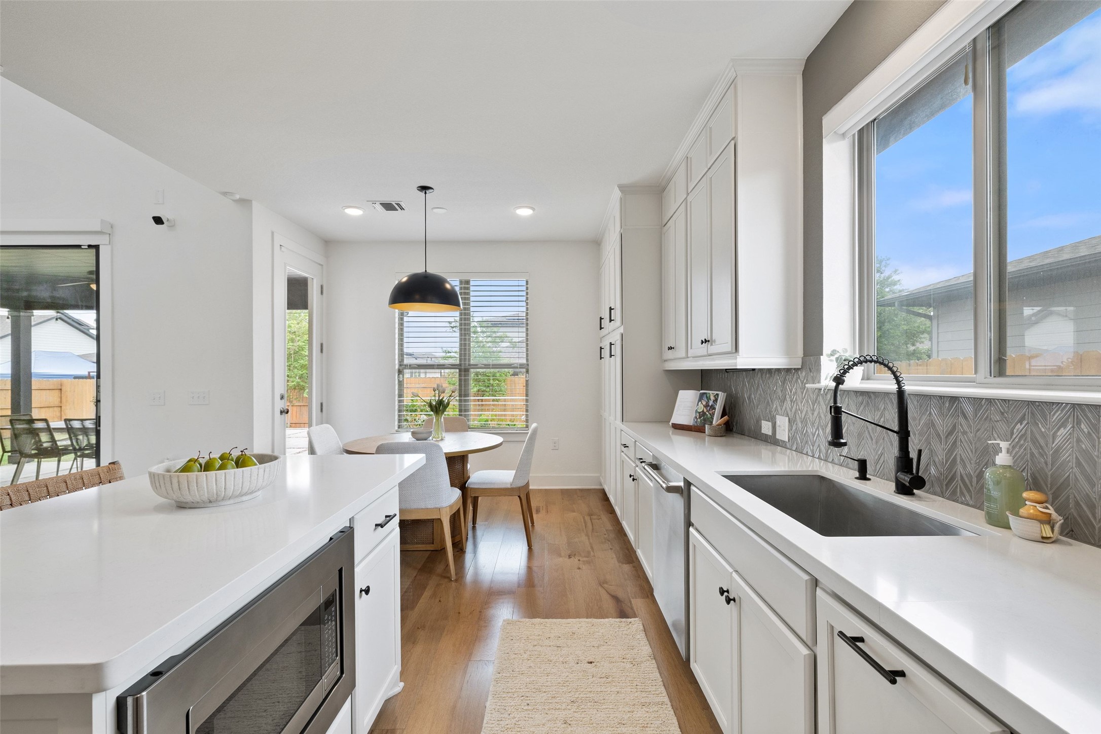 7908 Yokohama Terrace Austin, TX 78744 - Photo 16 of 40 a large white kitchen with cabinets a sink and a large window