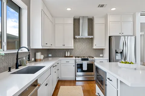 a kitchen with stainless steel appliances granite countertop a sink stove and refrigerator