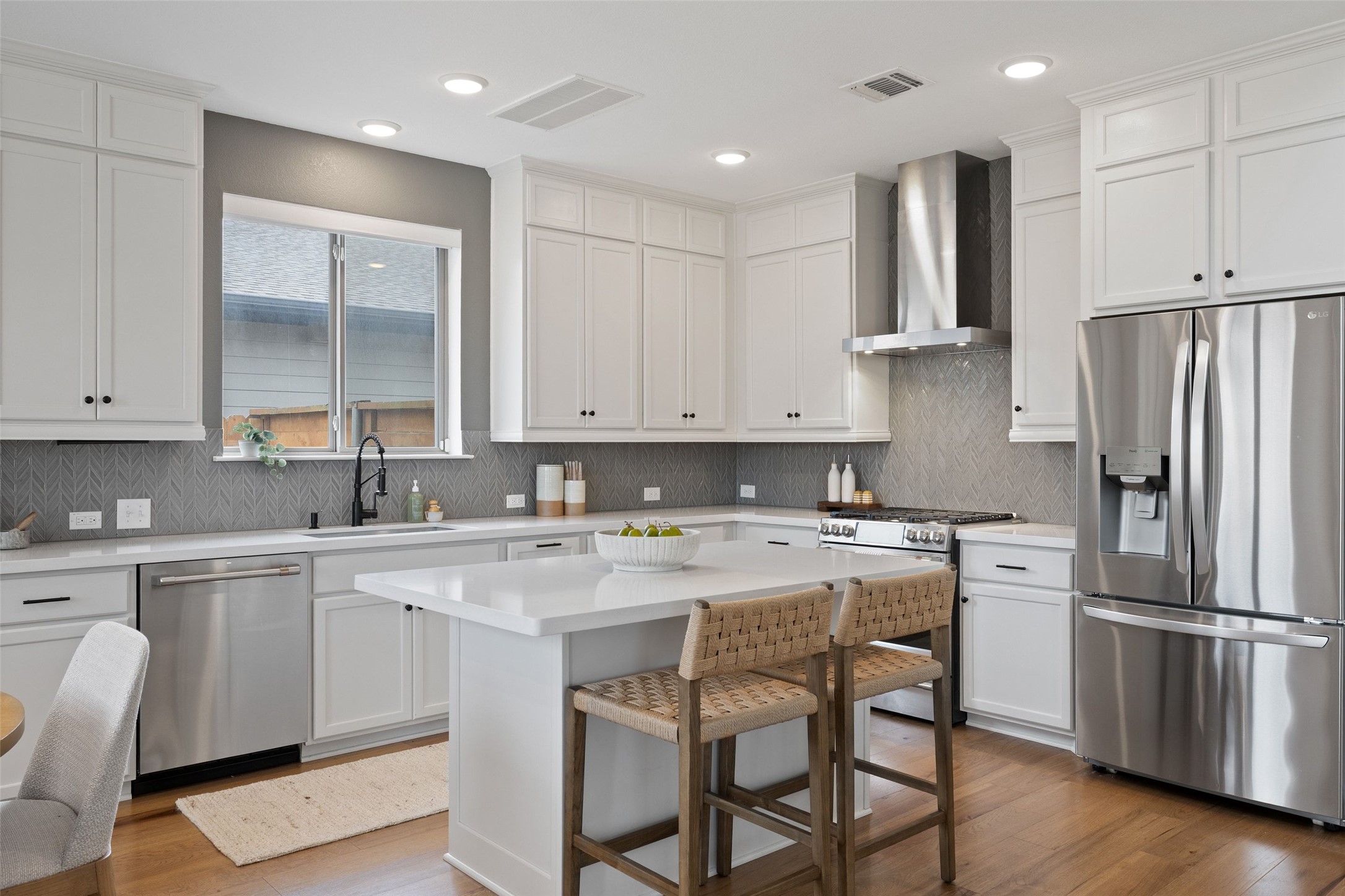 7908 Yokohama Terrace Austin, TX 78744 - Photo 4 of 40 a kitchen with a refrigerator a stove a sink and white cabinets with wooden floor