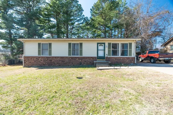 a front view of house with yard and trees around