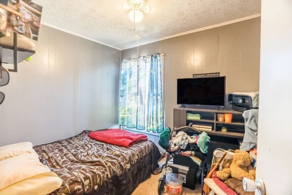 a bedroom with a bed and a flat screen tv