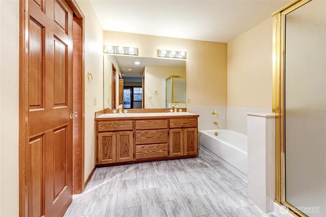 a bathroom with a bathtub sink and mirror
