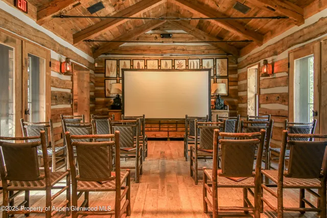 a living room with furniture a rug and a floor to ceiling window