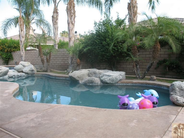 6 Varsity Circle Rancho Mirage, CA 92270 - Photo 18 of 21 a view of a lake with a house in the background