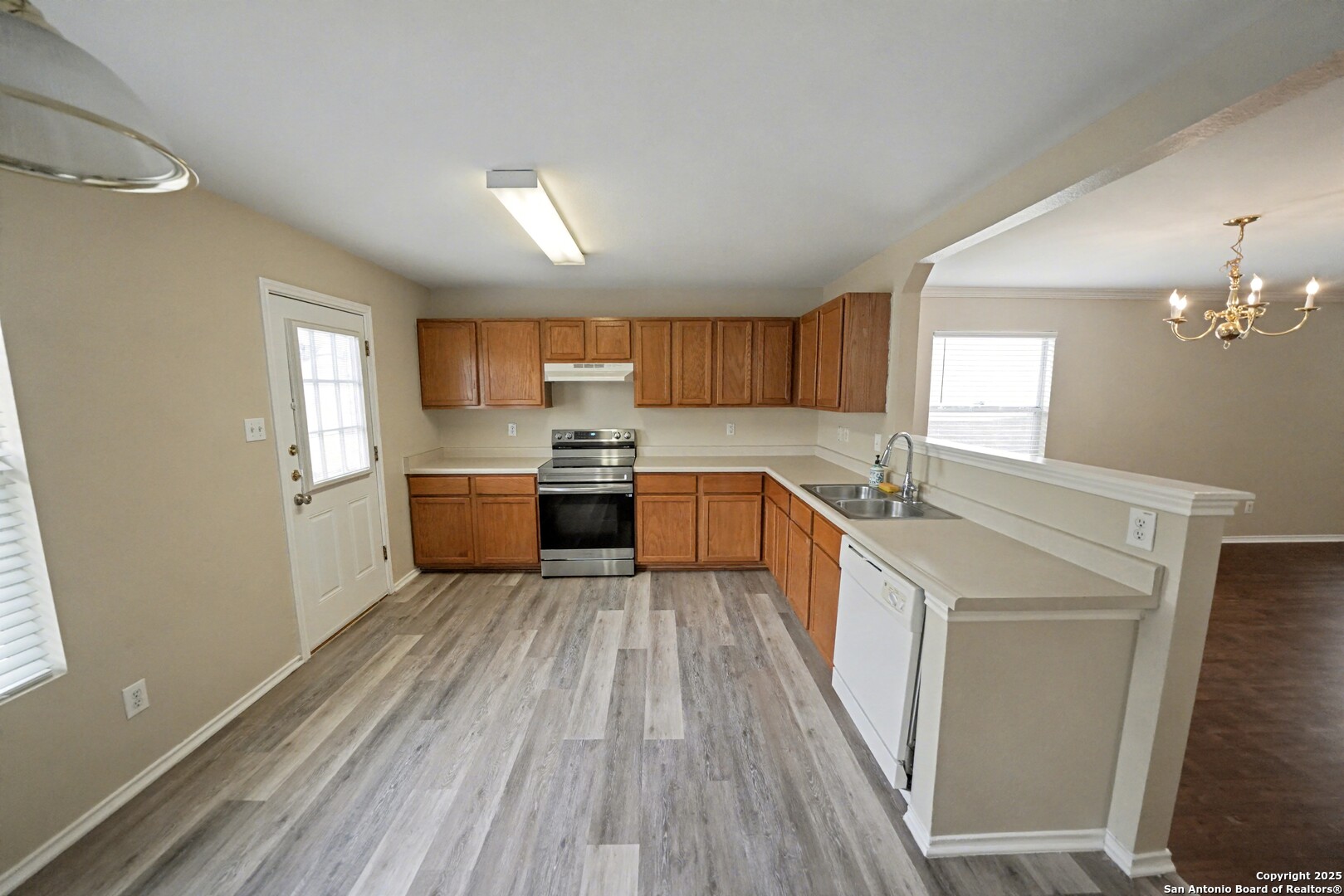 112 Stream Crossing Cibolo, TX 78108 - Photo 11 of 38 a large kitchen with stainless steel appliances kitchen island a large counter top and wooden floors