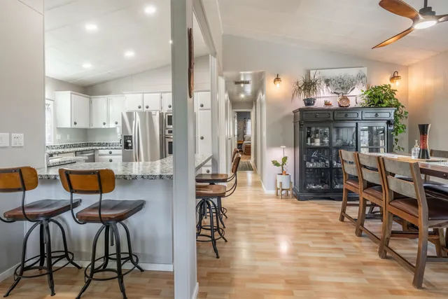 a living room with stainless steel appliances kitchen island granite countertop furniture and a wooden floors