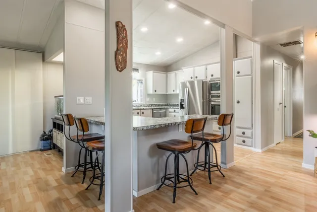 a kitchen with stainless steel appliances kitchen island granite countertop furniture and a refrigerator