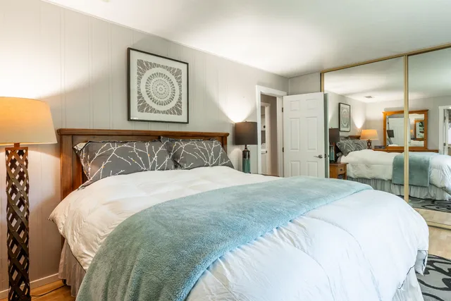 a bedroom with a bed and painting on the wall