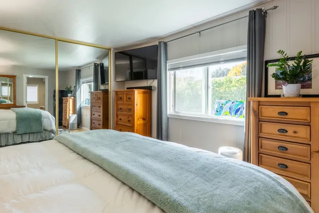 a bedroom with a large bed and a chandelier