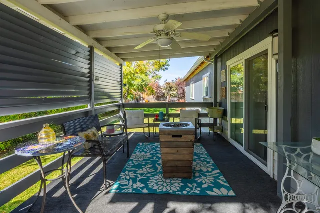 a living room with patio furniture and a floor to ceiling window