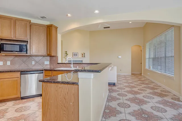 a kitchen with stainless steel appliances granite countertop a sink and a stove top oven