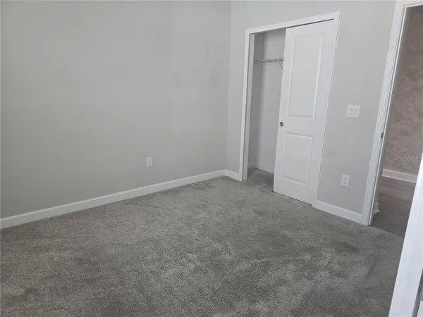 an empty room with windows and closet