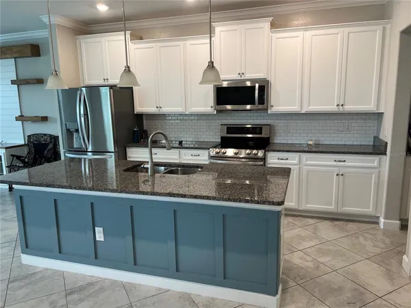 a kitchen with stainless steel appliances granite countertop a sink counter space cabinets and a counter space