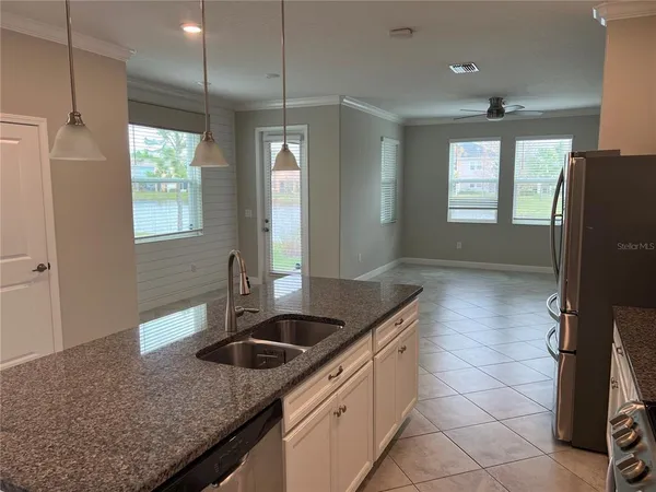 a kitchen with granite countertop a sink a counter top space and cabinets
