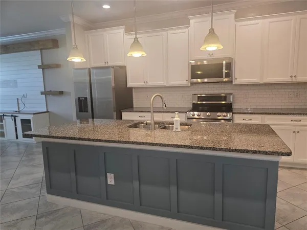 a kitchen with stainless steel appliances granite countertop a sink and a granite counter tops