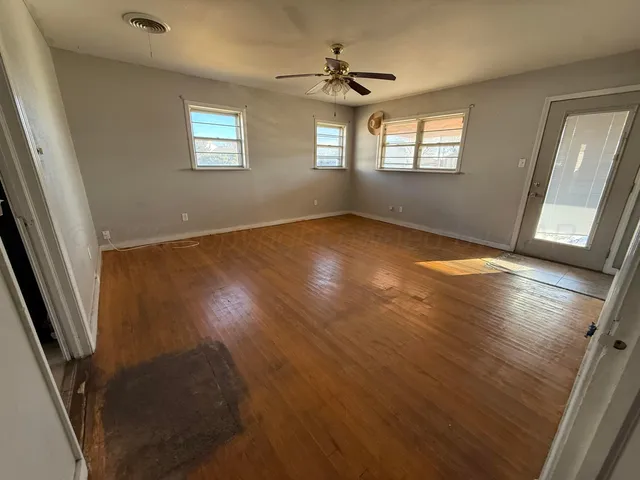 wooden floor in an empty room with a window