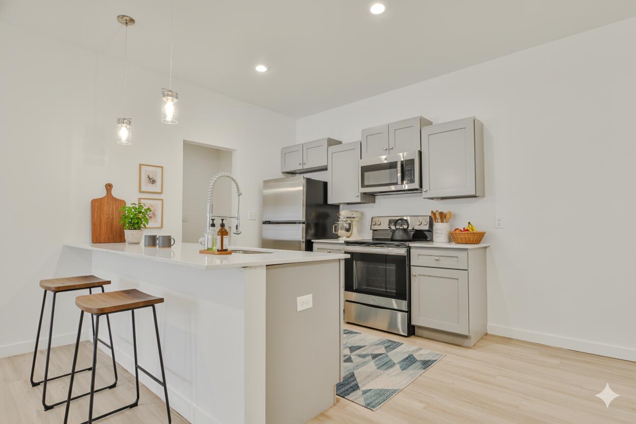 a kitchen with stainless steel appliances a stove a sink a microwave a refrigerator and cabinets