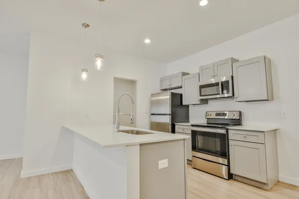 a kitchen with stainless steel appliances granite countertop a sink stove and refrigerator