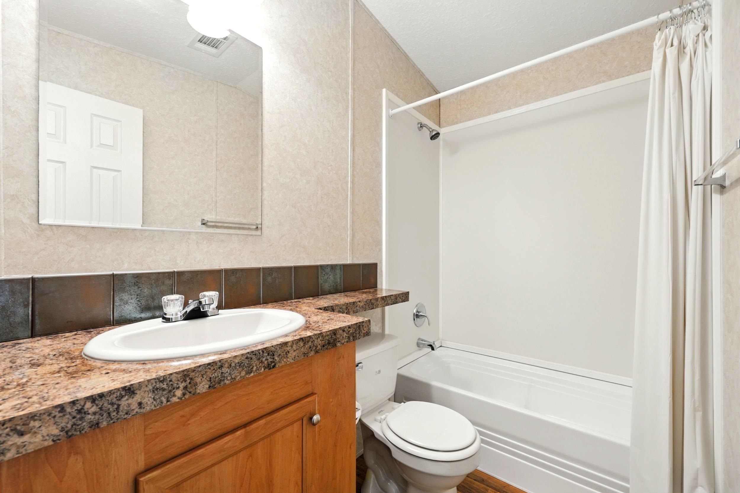 300 East Carter Street Hastings, FL 32145 - Photo 23 of 41 a bathroom with a granite countertop sink toilet and shower