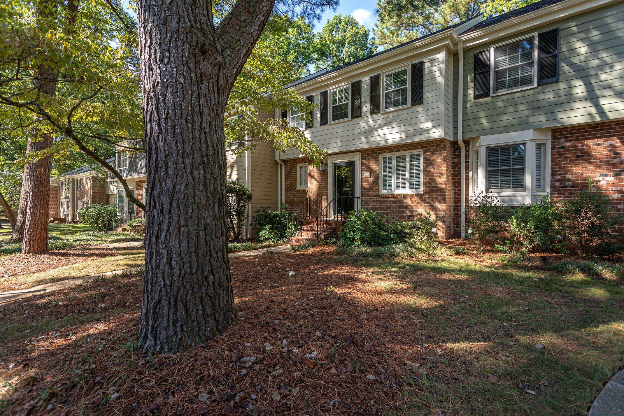 a front view of a house with a yard and tree s