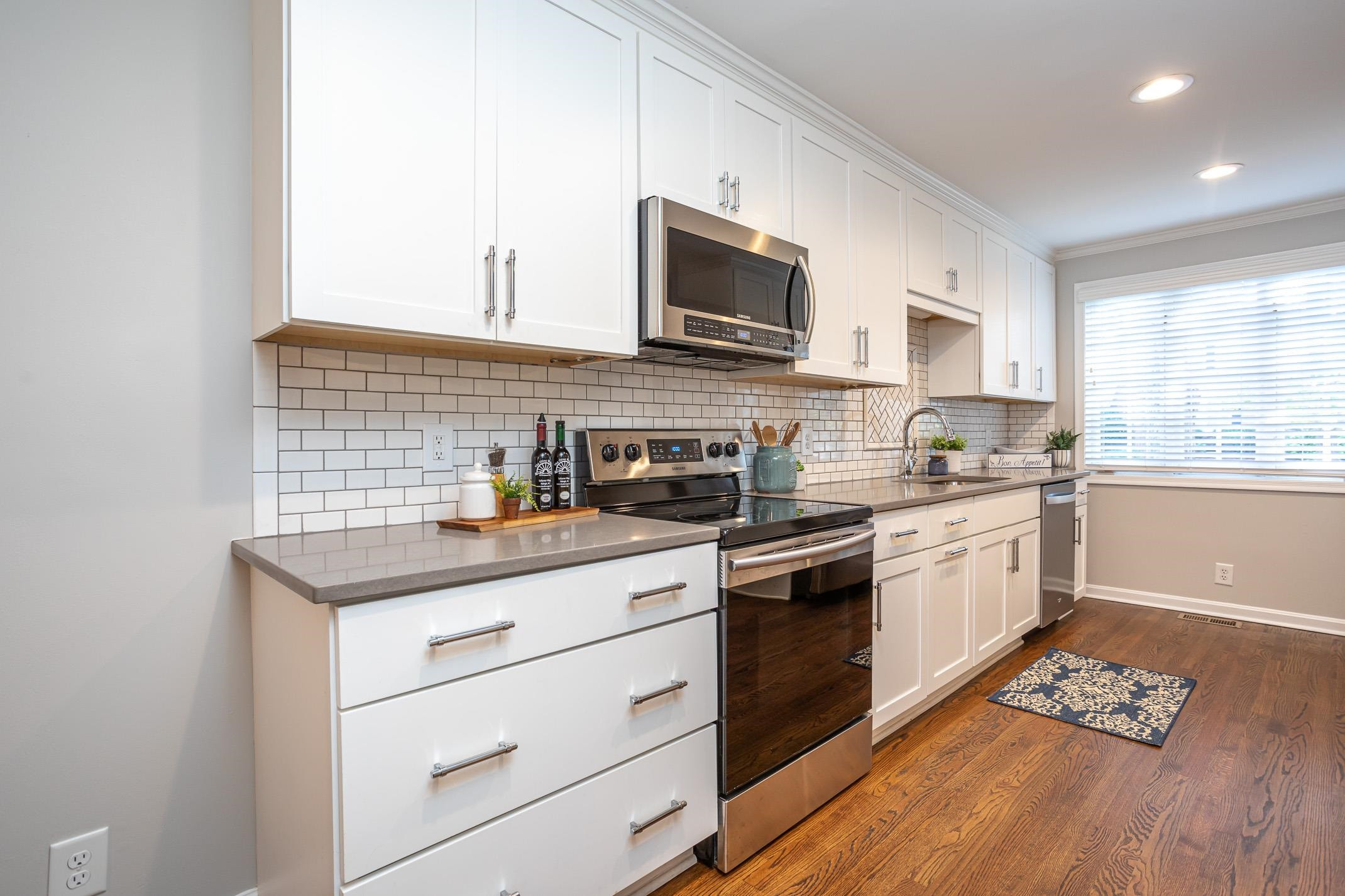 2943 Wycliff Road Raleigh, NC 27607 - Photo 10 of 31 a kitchen with stainless steel appliances kitchen island granite countertop a sink stove microwave and cabinets