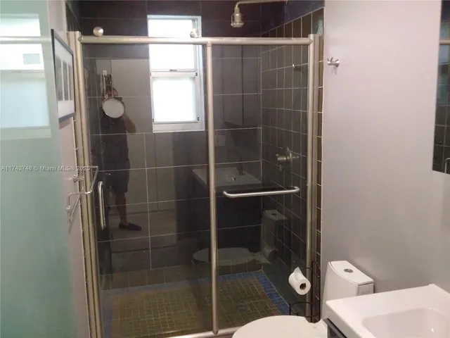 a bathroom with a shower a toilet and a sink