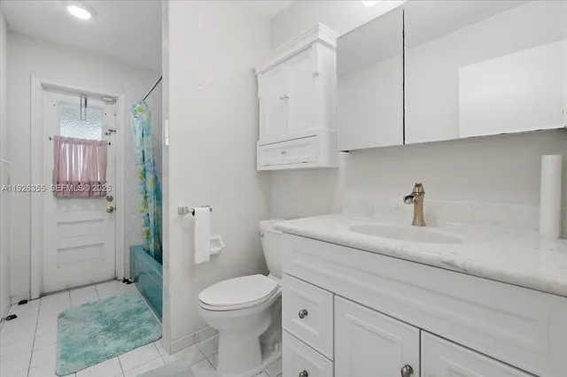 a bathroom with a granite countertop toilet sink and mirror
