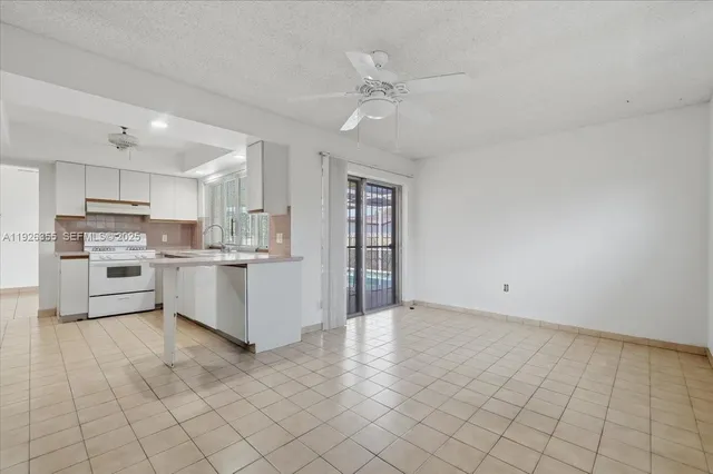 a view of kitchen with windows and refrigerator
