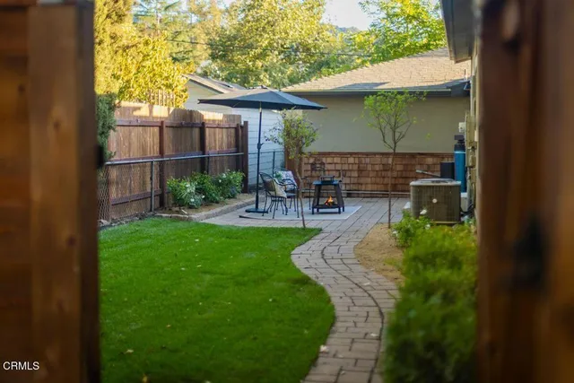 a view of a patio with table and chairs under an umbrella