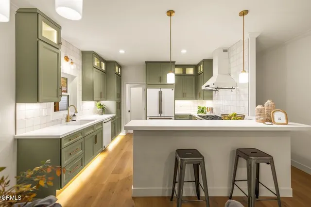 a kitchen with kitchen island granite countertop a sink a counter top stainless steel appliances and cabinets