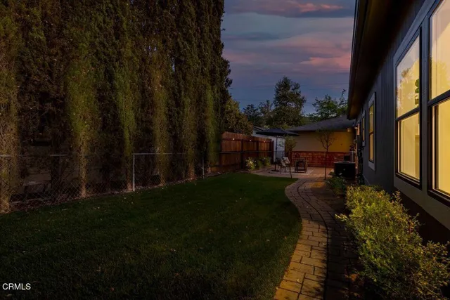 a view of house with backyard garden and patio