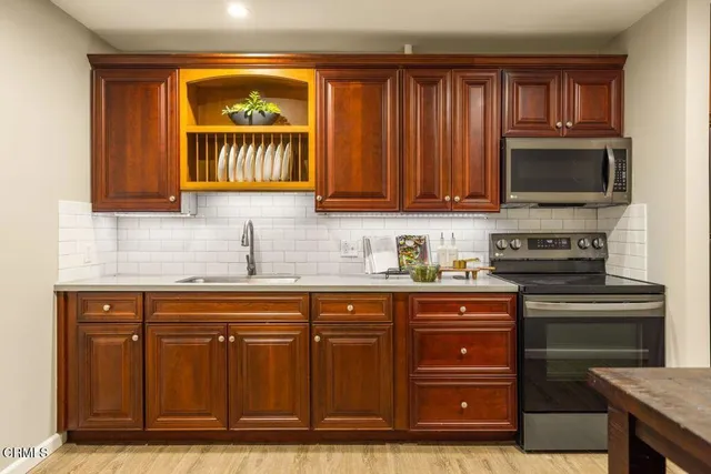a kitchen with granite countertop wooden cabinets and a stove top oven