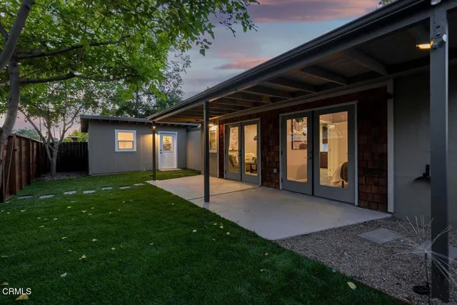 a view of an house with backyard and porch