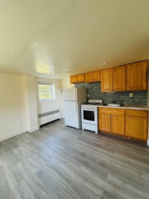 a kitchen with granite countertop a stove a sink and a refrigerator