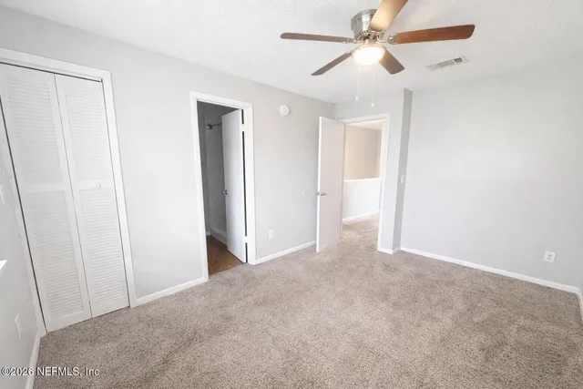 a view of empty room with a ceiling fan