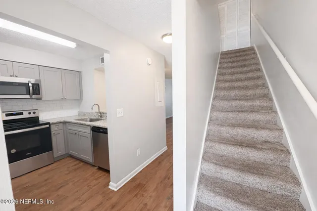 a view of a kitchen with sink microwave and stove