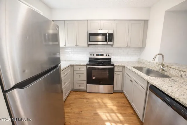a kitchen with a sink stove and microwave