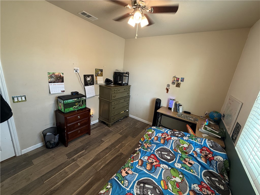 30130 Pine Needle Road Menifee, CA 92585 - Photo 11 of 45 a bedroom with furniture and a wooden floor