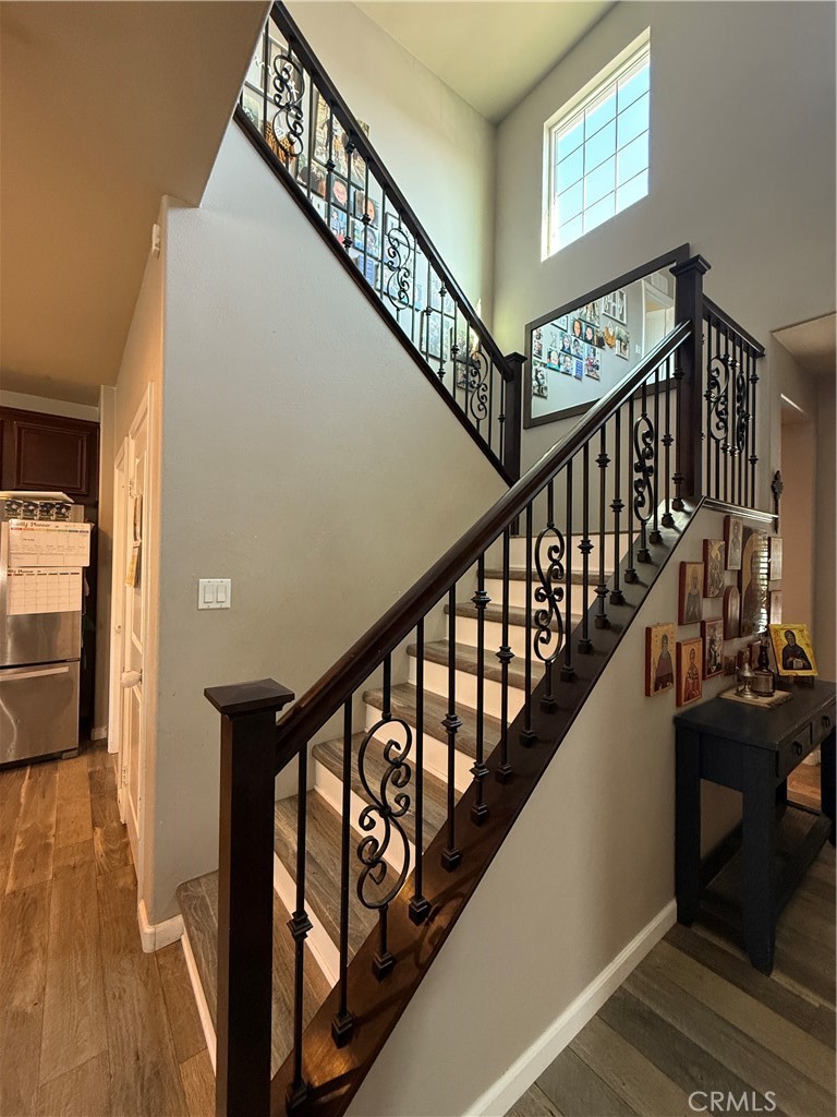 30130 Pine Needle Road Menifee, CA 92585 - Photo 19 of 45 a view of staircase with lots of frames on wall and wooden floor