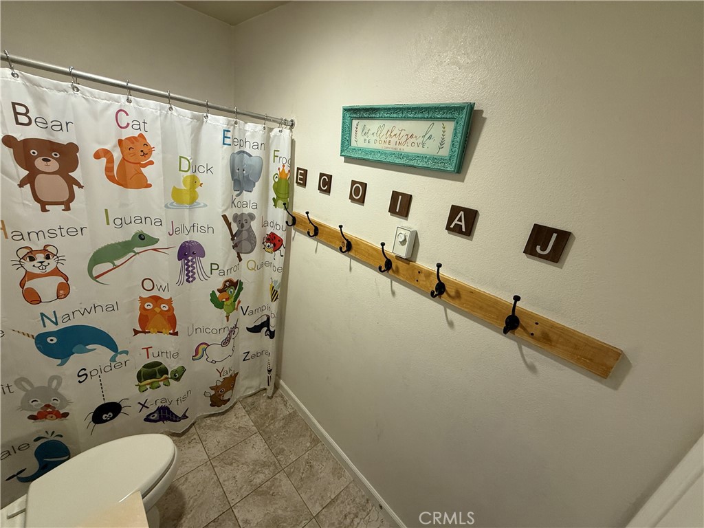 30130 Pine Needle Road Menifee, CA 92585 - Photo 20 of 45 a bathroom with a shower curtain
