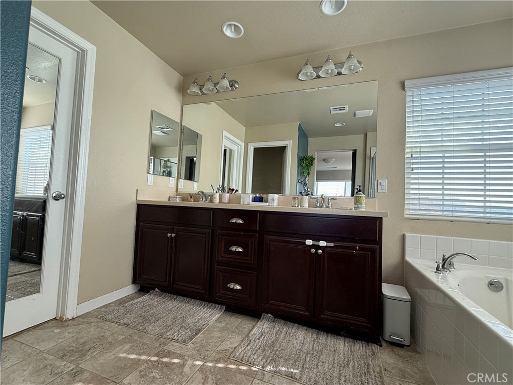 30130 Pine Needle Road Menifee, CA 92585 - Photo 27 of 45 a spacious bathroom with a tub sink and mirror