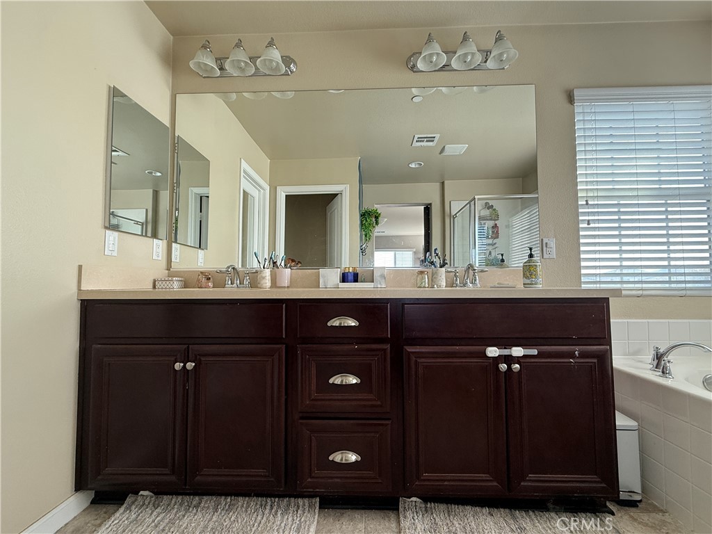 30130 Pine Needle Road Menifee, CA 92585 - Photo 28 of 45 a bathroom with a sink vanity and mirror